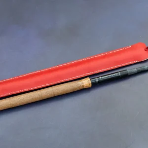 Fly Fishing Artisan 3.00m Tenkara rod with custom red leather case on natural river stones.